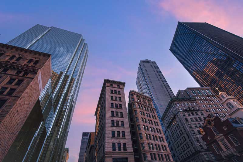 acquisition financing loans - photo of skyscrapers, shot from below at dusk, with a purplish sky.