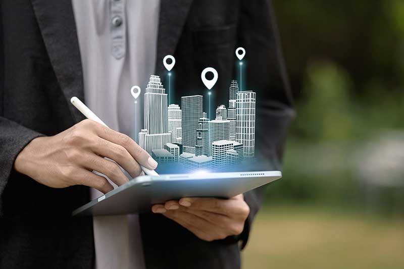 bridge loan commercial real estate - graphic of A person uses a tablet to project a holographic 3D model of a smart city with location markers. 