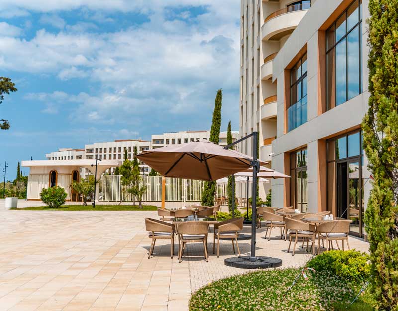 business loans for hospitality industry - photo of A modern summer promenade with palm trees and a garden and expensive hotels.