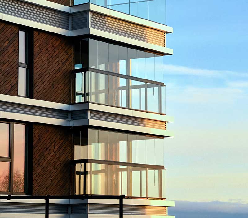 condo investment property loan - photo of condo building, at the corner, featuring three floors with balconies.
