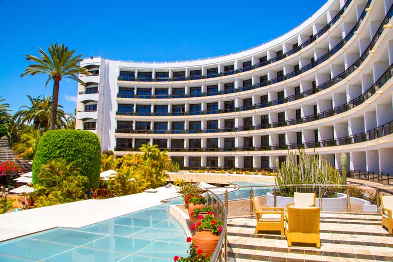 hotel construction loans - photo of Luxury hotel with infinity pool and palms all around it.