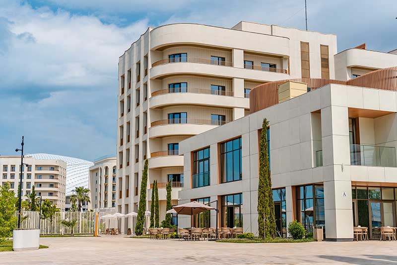 hotel loans and financing - photo of A modern summer promenade with palm trees and a garden and expensive hotels
