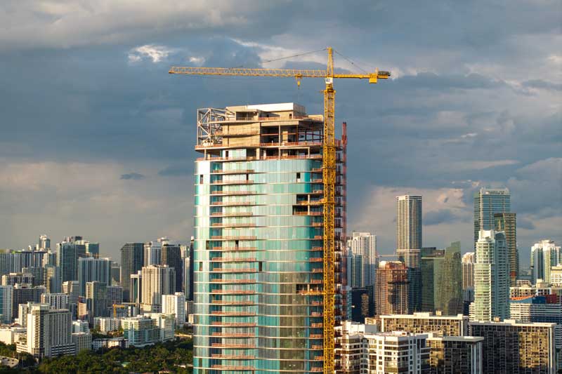 preferred equity and mezzanine financing providers - photo of skyscraper construction in progress with city in background.