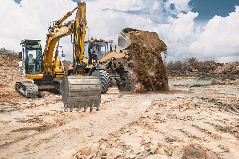 raw land financing - photo of construction vehicles on cleared construction site.