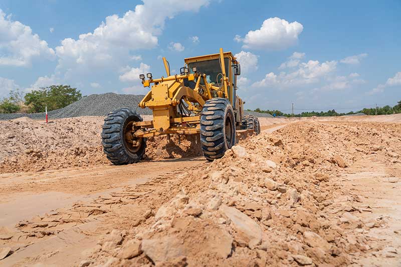 raw land loans - photo of construction vehicle on cleared construction site.